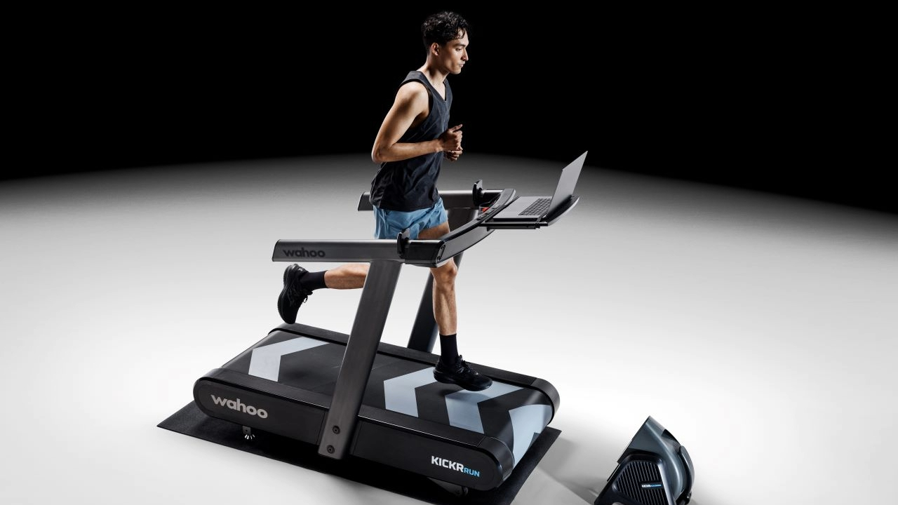athlete comparing treadmill workout data with smartwatch metrics during triathlon training