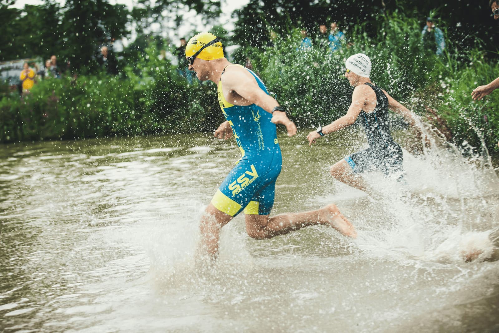 triathlon race start swimmers running into water
