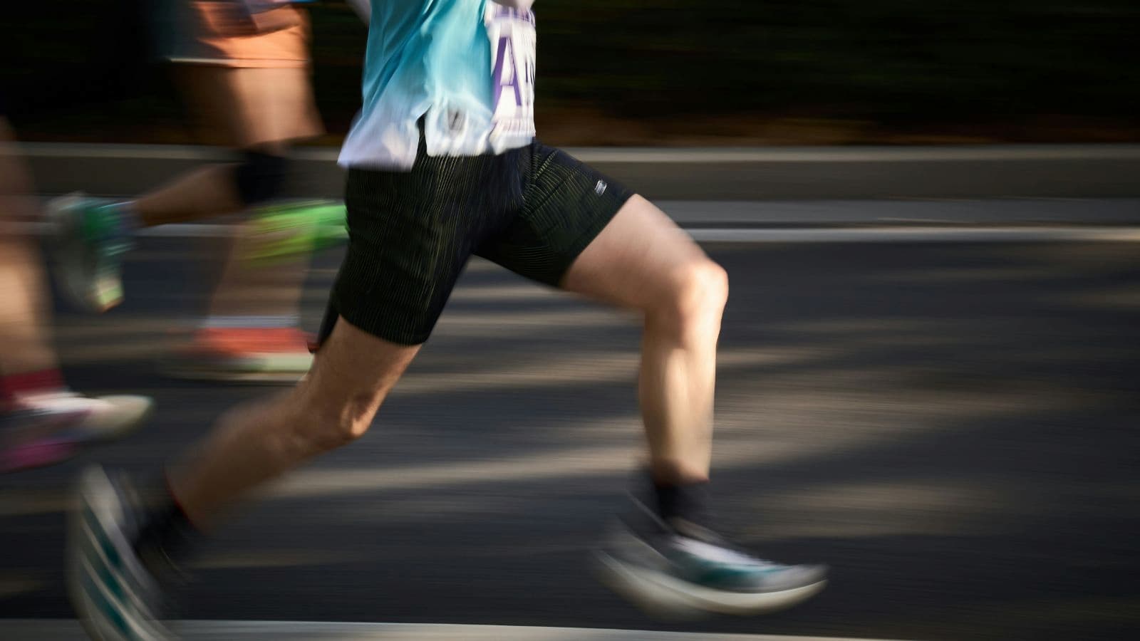 Runner’s legs in motion during training, showing stride efficiency and lower body endurance for triathlon preparation