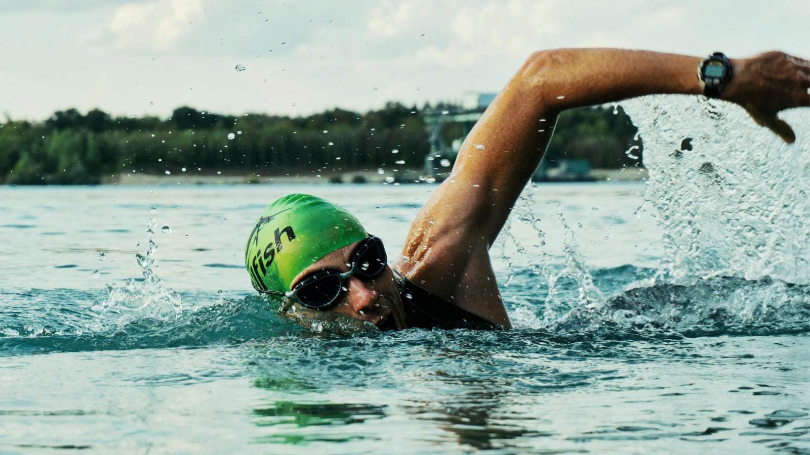Triathlete swimming in open water transitioning from pool training in a natural outdoor setting