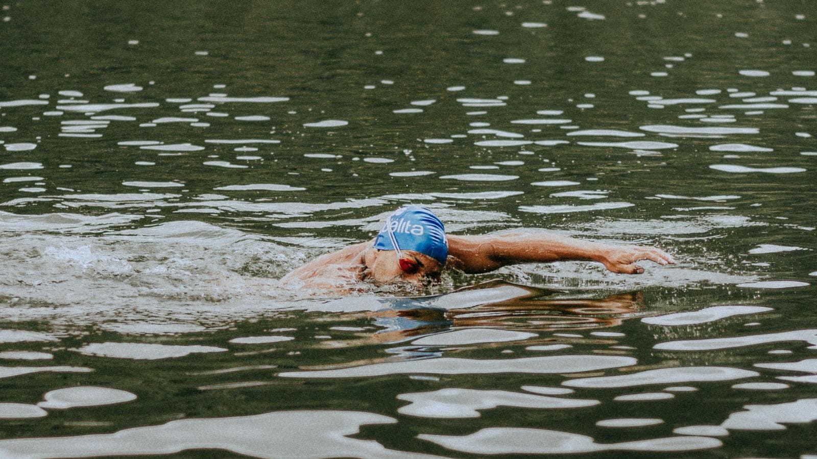 triathlete swimming in cold open water conditions during triathlon race performance training
